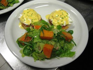 Eggs benedict com salada de agrião e sementes de girassol
