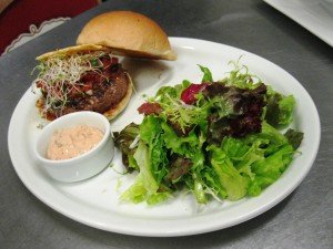 Cozinha Americana - Hamburguer com pico de gallo, guacamole, broto de alfafa e queijo frisco servido com salada verde